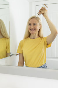 Middle age caucasian woman applies scalp peeling, scrub on head skin, hair. dandruff. blond white