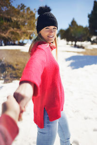 Smiling woman standing on snow covered land