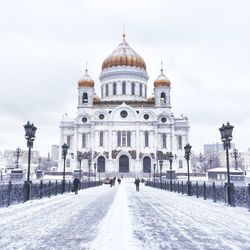 Snow covered road leading towards cathedral of christ the saviour against sky