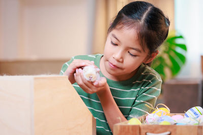 Close-up of girl holding baby rabbit