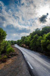 Road amidst trees against sky