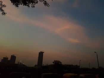 Silhouette of city against cloudy sky