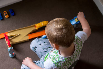 High angle view of boy playing with toy car at home