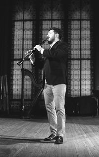 Man playing clarinet while standing at studio