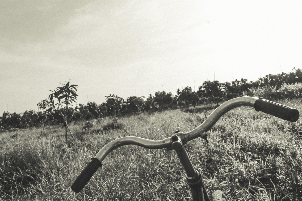 BICYCLE ON FIELD AGAINST CLEAR SKY