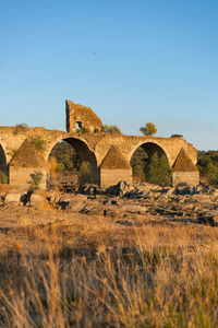 Arch bridge against clear blue sky