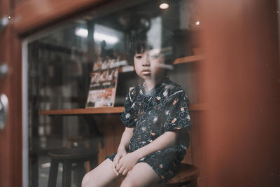 Sad boy sitting on table at cafe