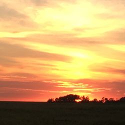 Scenic view of silhouette landscape against orange sky