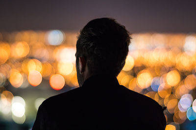 Rear view of silhouette man standing at night