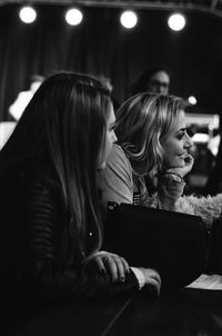 Female friends looking away while sitting in restaurant
