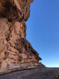 Low angle view of rock formation against clear blue sky