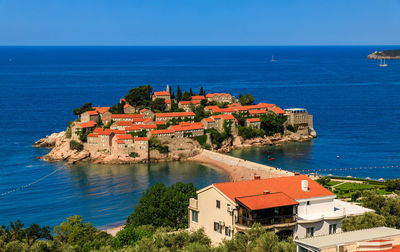 High angle view of townscape by sea against sky