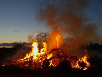 Lit bonfire during easter against sky