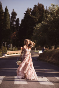 Rear view of woman sitting on road