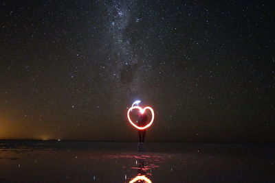 View of sea against star field at night