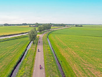 Road amidst field against clear sky