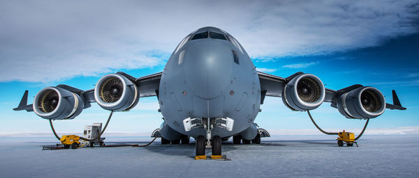 Low angle view of airplane on airport runway against sky