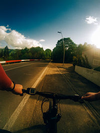 Man riding bicycle on road against sky