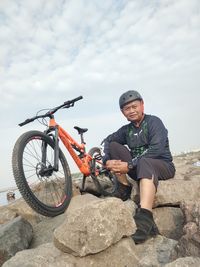 Portrait of young man riding bicycle on rock