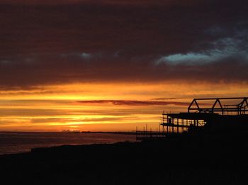 Scenic view of sea against cloudy sky during sunset