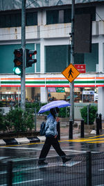 Full length of man walking on street in rainy season