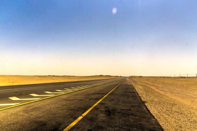 Road passing through landscape against clear sky