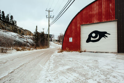 Road sign against sky during winter