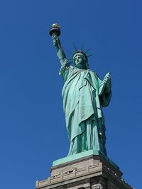 Low angle view of statue against blue sky