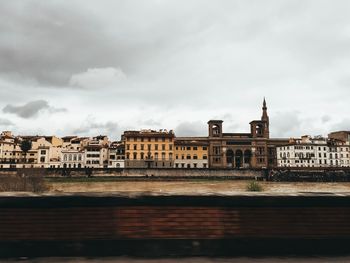 Buildings in city against cloudy sky