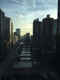 Buildings in city against cloudy sky