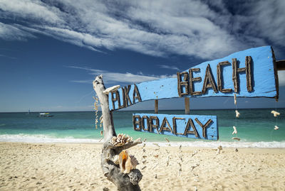 Text on beach against sky