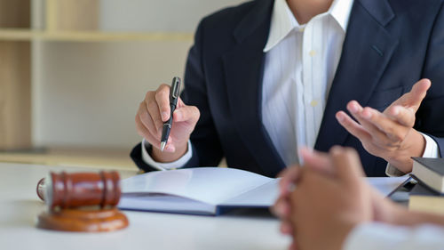 Midsection of woman holding umbrella on table