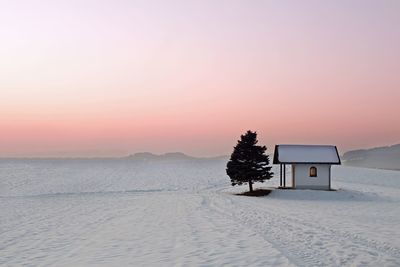 Scenic view of snow covered land during sunset