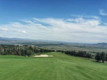 Scenic view of golf course against sky