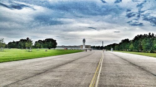 Empty road against cloudy sky