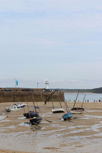 Boats moored on beach against sky