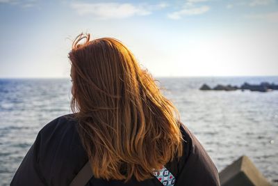 Rear view of woman looking at sea against sky