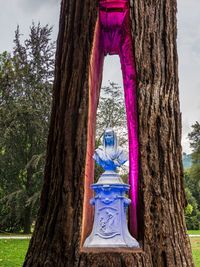 Low angle view of statue against tree trunk