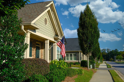 Houses amidst trees and buildings against sky