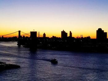 View of suspension bridge in city at sunset