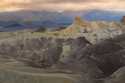 Scenic view of mountain range against cloudy sky