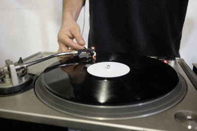 Midsection of man playing record