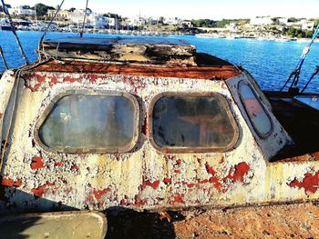 Close-up of abandoned boat against sea