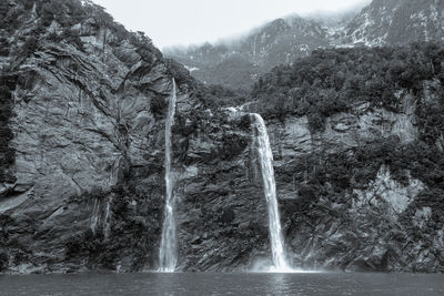 Scenic view of waterfall against mountains