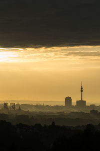 Silhouette buildings against sky during sunset