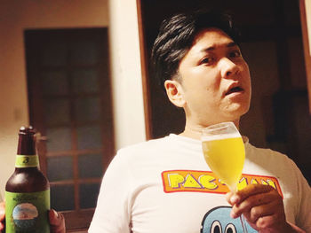 Full length of man drinking beer in glass