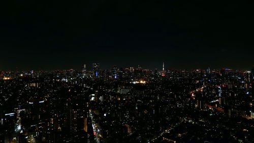 High angle view of illuminated buildings against sky at night