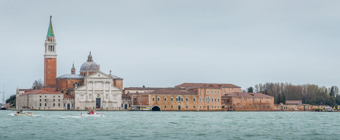 View of buildings by sea against sky