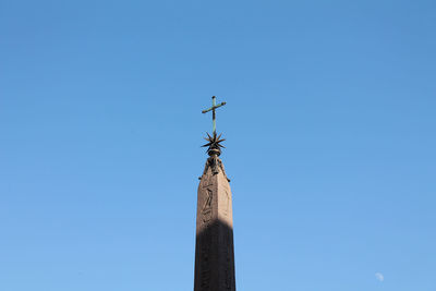 Low angle view of cross on pole against clear sky