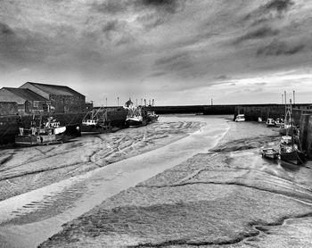 Boats at harbor against sky